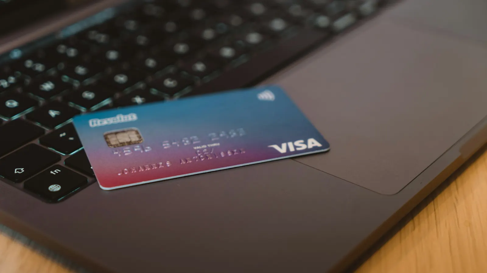 Debit card resting on a laptop keyboard