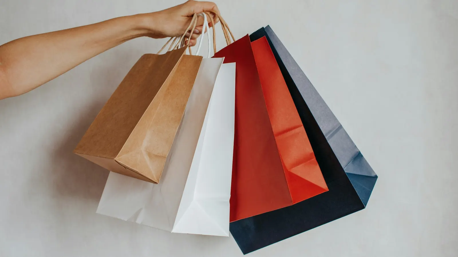 Hand holding colourful shopping bags