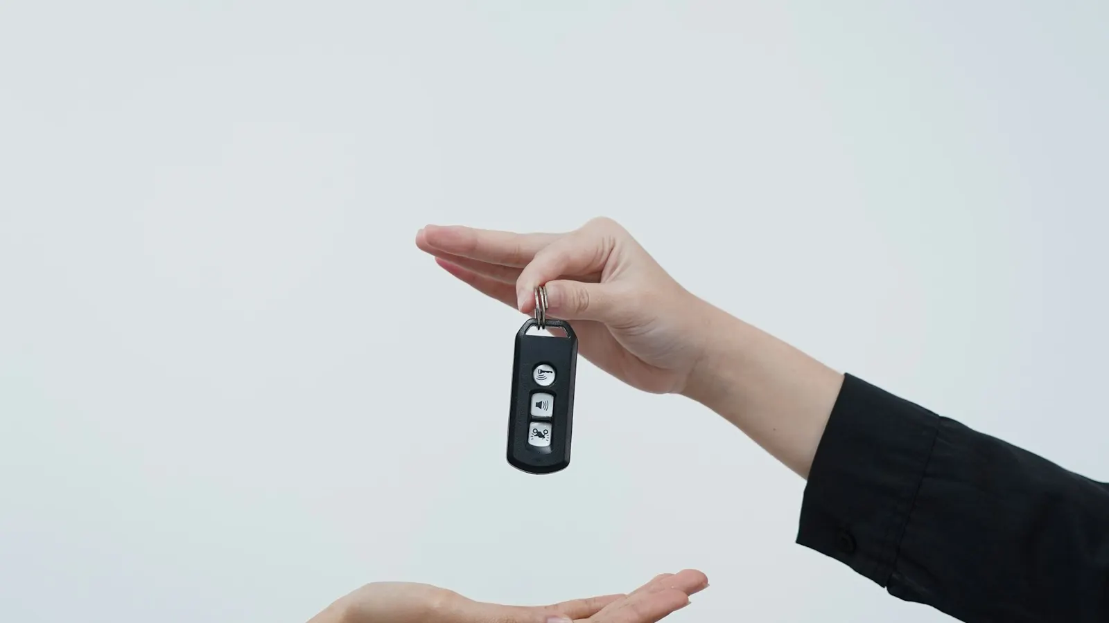 One hand passing a car key to another