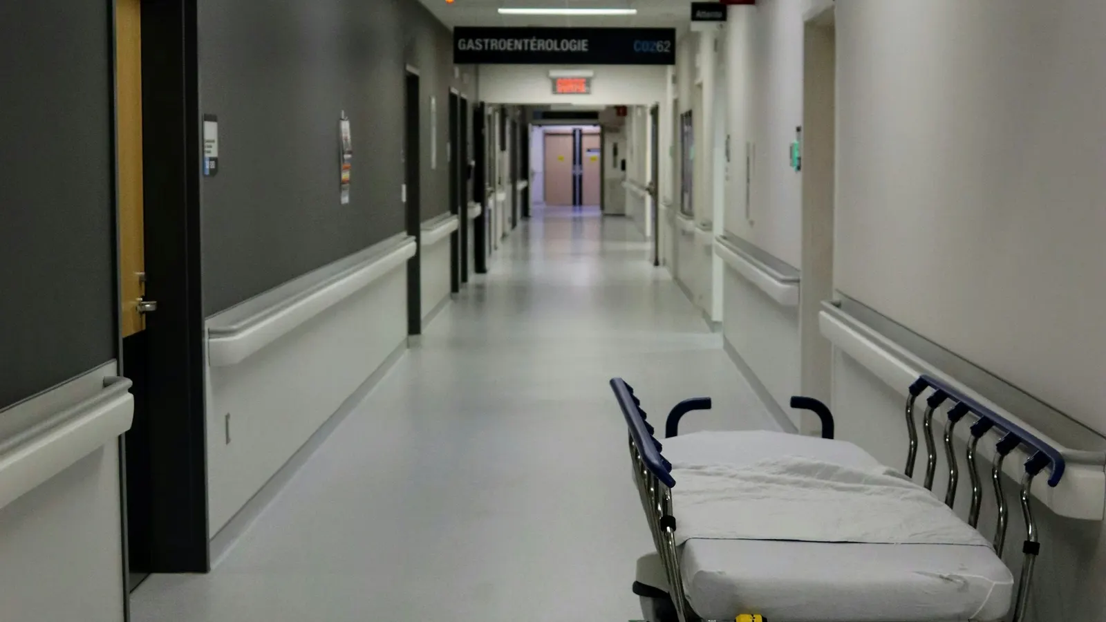 Hospital corridor with an empty bed