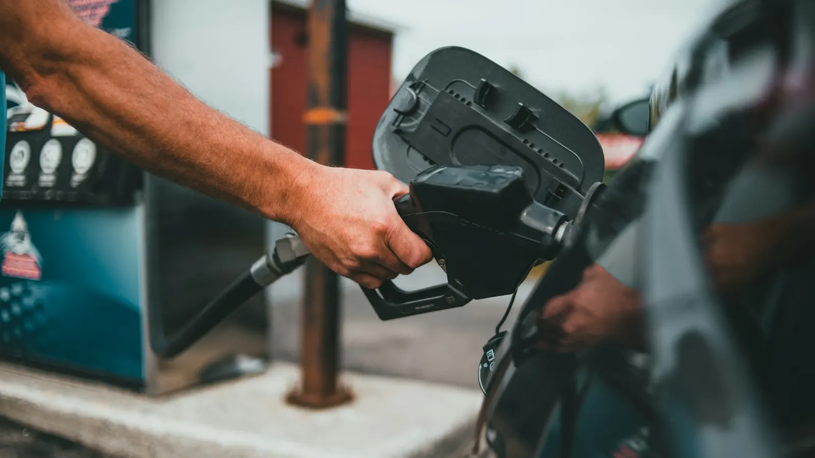 Person filling a car with fuel at a petrol pump