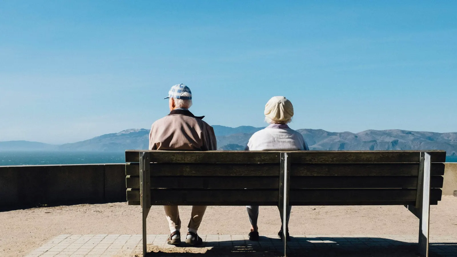 Couple sitting on a bench looking out to sea