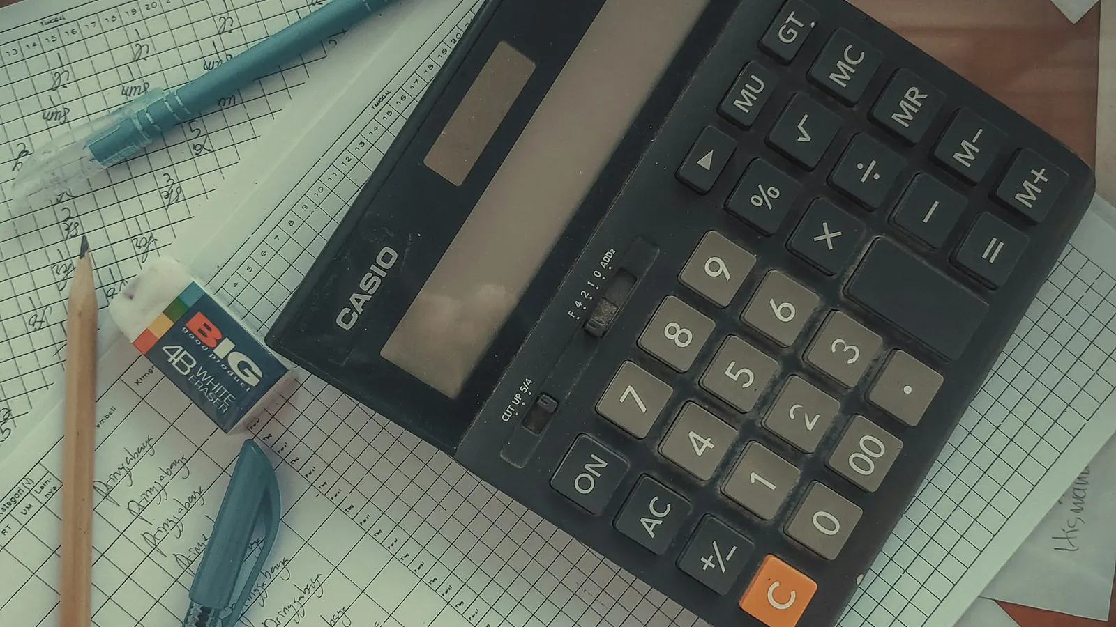Calculator resting on a pile of papers